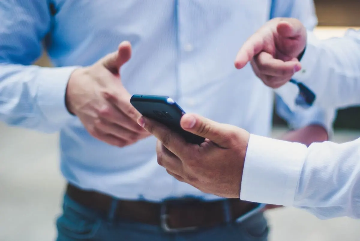 A person showing another person something on their phone.