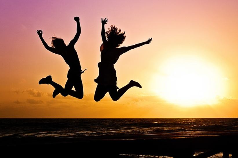 silhouettes-of-two-girls-jumping-in-the-air-on-the-beach