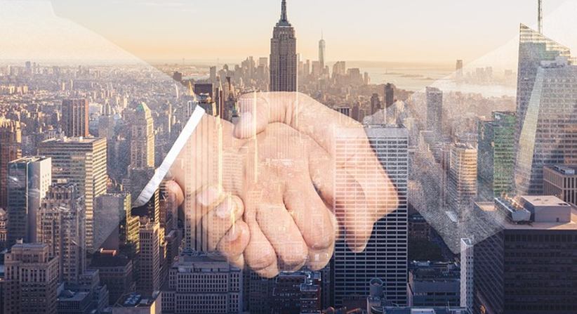 business-handshake-with-cityscape-background