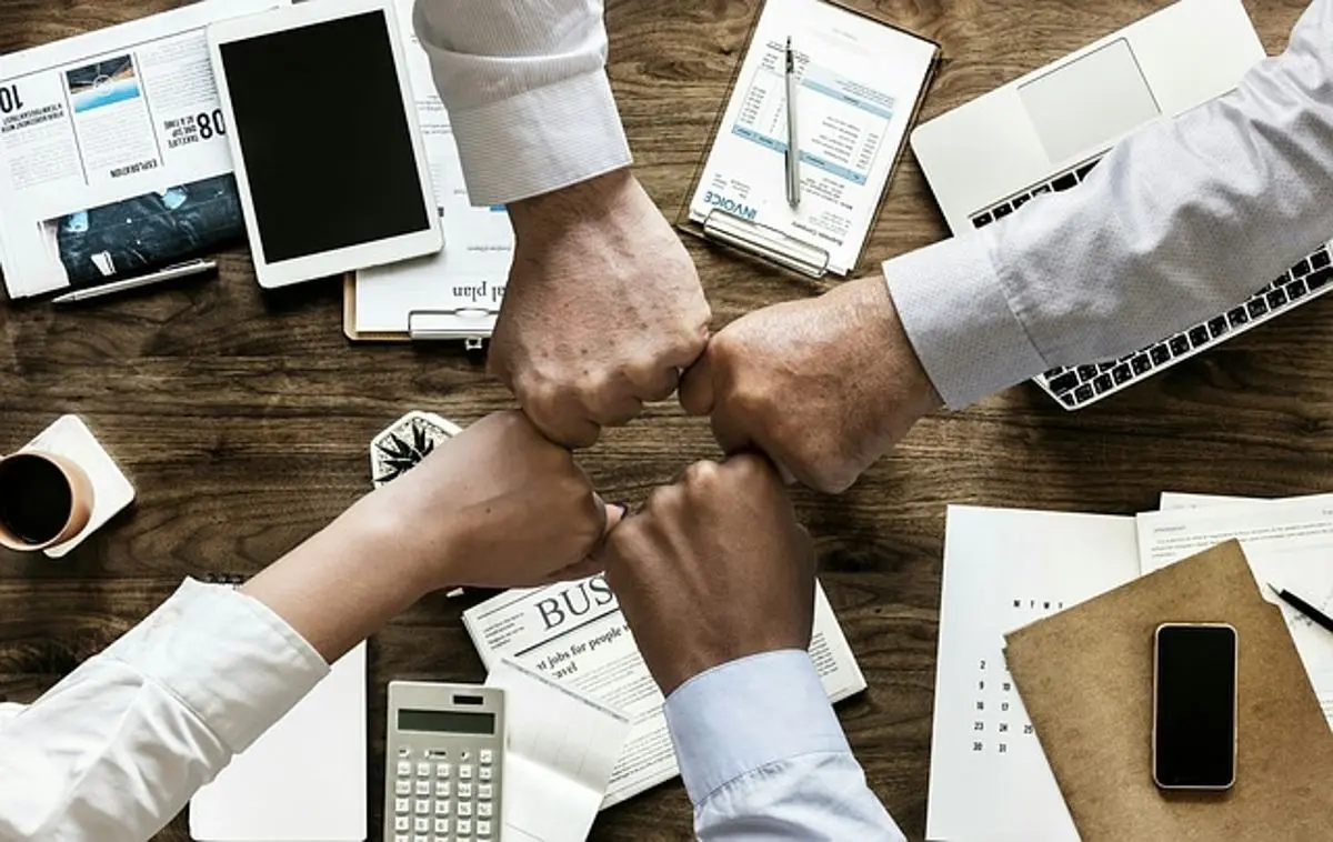 four-business-team-members-bumping-hands