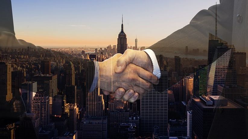 businessmen-shake-hands-cityscape-background