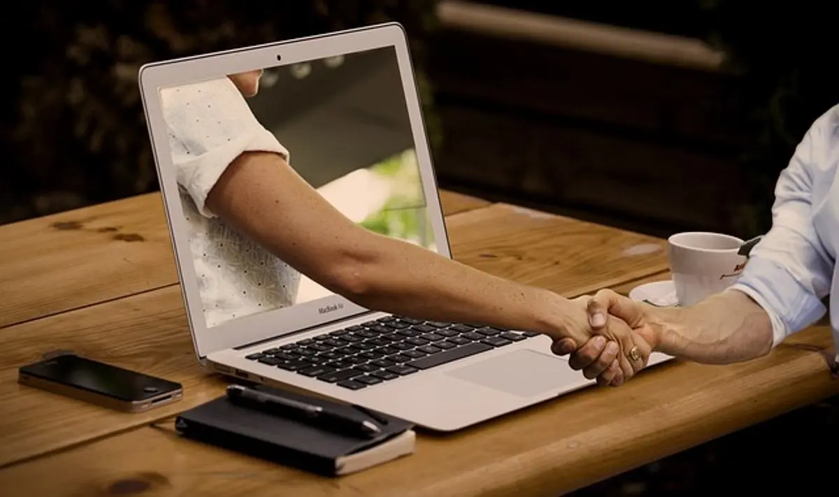 people-shaking-hands-through-a-laptop-screen