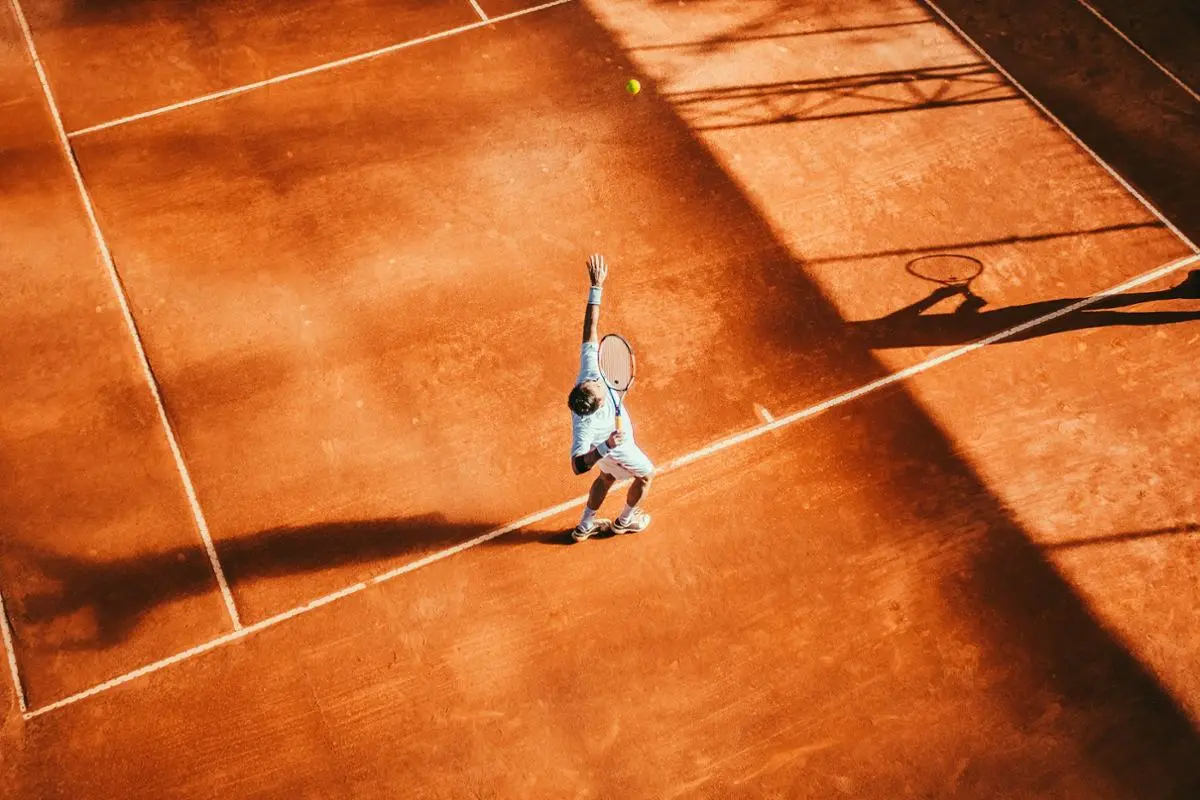 A tennis player preparing to serve.