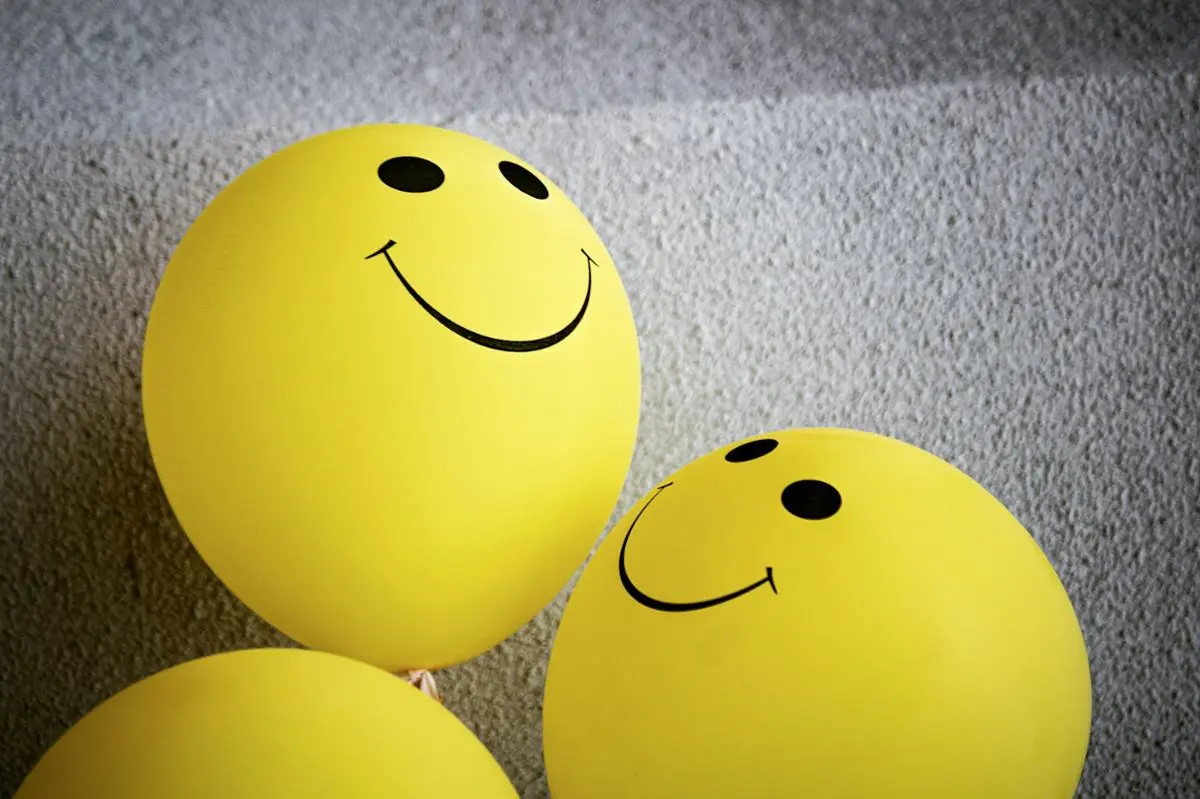 Several yellow balloons with smiley faces on them.