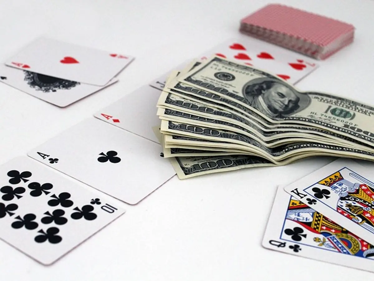 us-100-dollar-bills-and-playing-cards